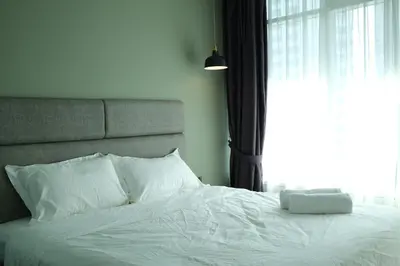 a bedroom with a white bed with a window at Atmoods - Vortex KLCC in Kuala Lumpur