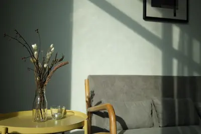 a vase of flowers on a table next to a couch at Atmoods - Vortex KLCC in Kuala Lumpur
