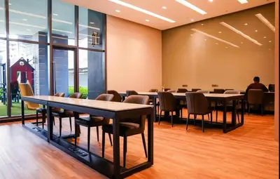a conference room with tables and chairs and a man sitting at a table at Atmoods - Star Residence in Kuala Lumpur