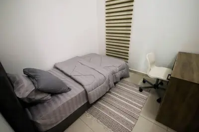 a bedroom with a bed and a desk and a chair at Legasi Kampung Baru by Airhost in Kuala Lumpur