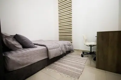 a bedroom with a bed and a desk and a chair at Legasi Kampung Baru by Airhost in Kuala Lumpur