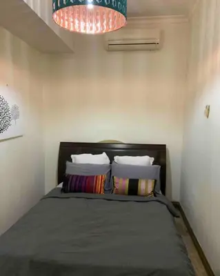 a bedroom with a bed with pillows and a chandelier at Charming apartment with Netflix at PWTC in Kuala Lumpur