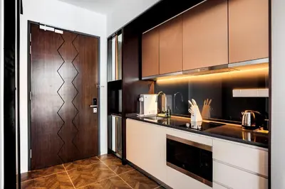 a kitchen with brown cabinets and a counter top at Scarletz Suites KLCC by Mana-Mana in Kuala Lumpur