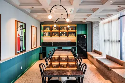 a dining room with a table and chairs and a couch at Scarletz Suites KLCC by Mana-Mana in Kuala Lumpur
