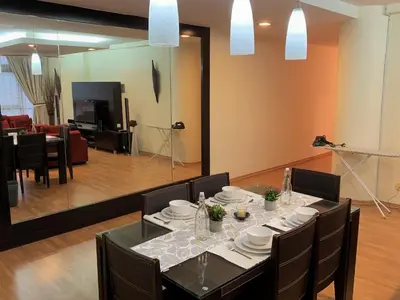 a dining room with a table and a living room at Bukit Bintang Fahrenheit88 Apartment by Sarah's Lodge in Kuala Lumpur
