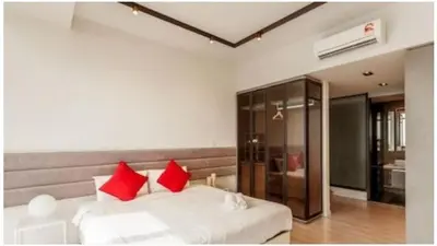 a bedroom with a white bed with red pillows at EXPRESSIONZ by GSuites in Kuala Lumpur