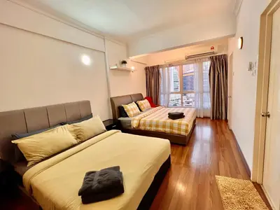 a bedroom with two beds and a couch and a window at Casa Mutiara Apartments by Moonlight in Kuala Lumpur