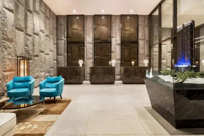 a lobby with blue chairs and a table at 8 Kia Peng Residences by Times 8 in Kuala Lumpur