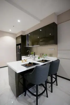 a kitchen with a large white island with chairs at 8 Kia Peng Residences by Times 8 in Kuala Lumpur
