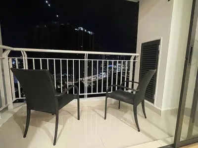 two chairs and a table on a balcony at night at Staycation with Private Jacuzzi @ KL Downtown 1711 in Kuala Lumpur