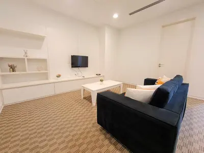 a living room with a black couch and a tv at KLCC Binjai 8 Premium Soho Apartment by Sarah's Lodge in Kuala Lumpur