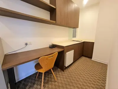 a small kitchen with a wooden desk and a chair at KLCC Binjai 8 Premium Soho Apartment by Sarah's Lodge in Kuala Lumpur
