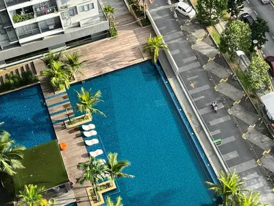 an overhead view of a swimming pool with chairs and palm trees at Kama Homestay @Wangsa Maju in Kuala Lumpur