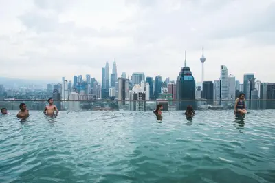 a group of people in a infinity pool with a city skyline at La Vista @ Regalia Residence in Kuala Lumpur