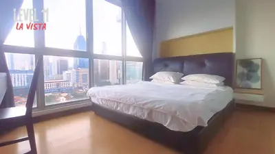 a bedroom with a bed with a large window at La Vista @ Regalia Residence in Kuala Lumpur