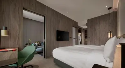 a hotel room with a large bed and a mirror at Pan Pacific Serviced Suites Kuala Lumpur in Kuala Lumpur