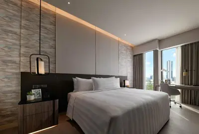 a bedroom with a large bed and a large window at Pan Pacific Serviced Suites Kuala Lumpur in Kuala Lumpur