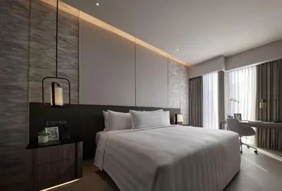 a bedroom with a large white bed and a window at Pan Pacific Serviced Suites Kuala Lumpur in Kuala Lumpur