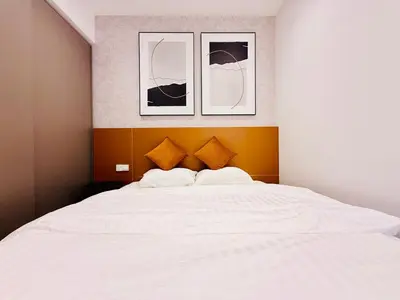 a bedroom with a white bed with three pictures on the wall at Eaton residences KLCC m@h in Kuala Lumpur