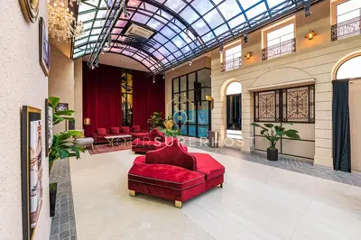 a lobby with two red couches and a glass ceiling at Scarletz Suites near KLCC by YourSuperhost in Kuala Lumpur