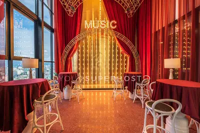 a room with red curtains and chairs and a stage at Scarletz Suites near KLCC by YourSuperhost in Kuala Lumpur