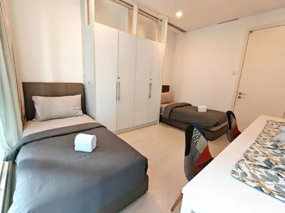 a bedroom with two beds and a table with chairs at Bukit Bintang KLCC Binjai 8 Premium Soho Apartment by Sarah's Lodge in Kuala Lumpur