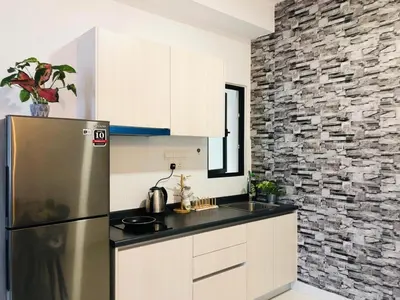 a kitchen with a refrigerator and a stone wall at PARC 3 in Cheras, #Sunway Velocity #IKEA #TRX in Kuala Lumpur