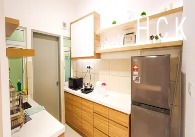 a kitchen with a stainless steel refrigerator and wooden cabinets at Titiwangsa Core at TR Residence by HCK in Kuala Lumpur