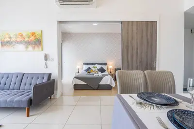 a bedroom with a bed and a table and chairs at Cozy Oasis near Ikea TRX Mall King Size Bed 100mb in Kuala Lumpur