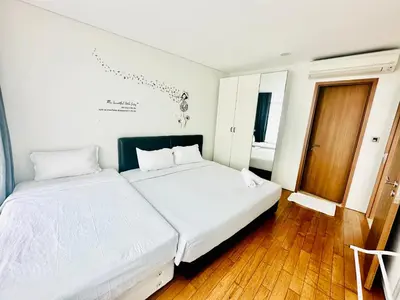 a bedroom with two white beds and a wooden floor at near klcc vortex suites by PLUS POIN in Kuala Lumpur