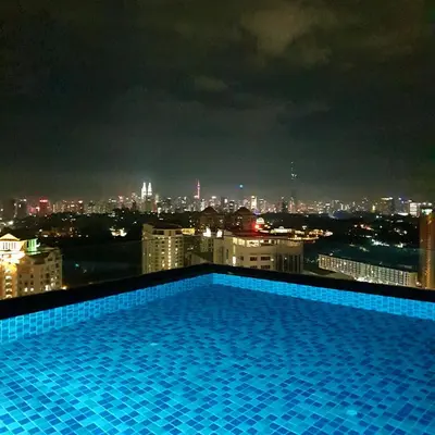 a swimming pool on the roof of a building at night at Mont Kiara 163 Mall (The Ooak) Private Room in Kuala Lumpur