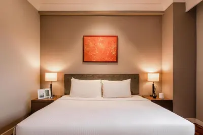 a bedroom with a large white bed with two lamps at Domitys Bangsar Kuala Lumpur in Kuala Lumpur