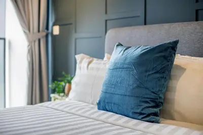 a bed with blue and white pillows and a window at Continew Residence KL CoBNB in Kuala Lumpur