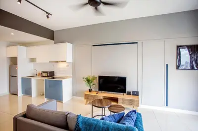 a living room with a couch and a table and a kitchen at Continew Residence KL CoBNB in Kuala Lumpur