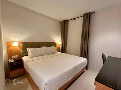 a bedroom with a white bed and a desk and a table at D Loft Hotel in Kuala Lumpur