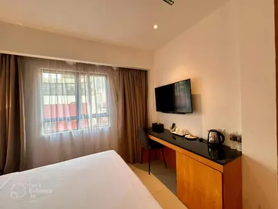 a hotel room with a bed and a desk with a television at D Loft Hotel in Kuala Lumpur