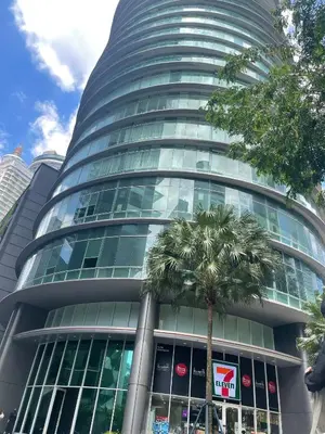 a tall building with a palm tree in front of it at KLCC vortex apartment suites Kuala Lumpur in Kuala Lumpur