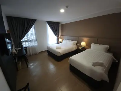 a hotel room with two beds and a window at Yu Hotel Chinatown in Kuala Lumpur