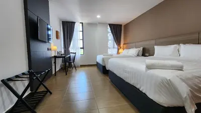 a hotel room with two beds and a flat screen tv at Yu Hotel Chinatown in Kuala Lumpur