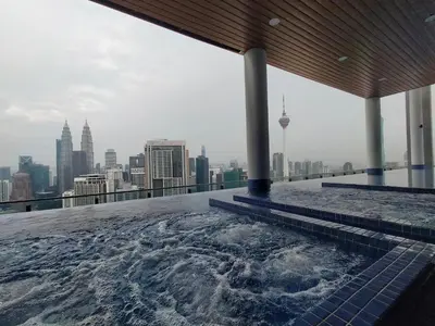 a hot tub on top of a building with a view of the city at Colony ( Wisma Infinitum ) in Kuala Lumpur