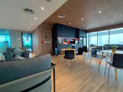 a living room with chairs and tables and windows at Colony ( Wisma Infinitum ) in Kuala Lumpur