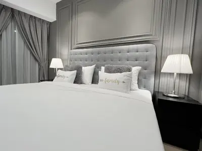 a bedroom with a large white bed with two lamps at The Eaton Residences by Times 8 in Kuala Lumpur