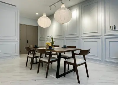 a dining room with a table and chairs and lights at The Eaton Residences by Times 8 in Kuala Lumpur