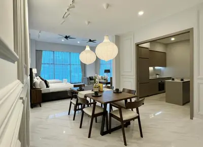 a dining room and living room with a table and chairs at The Eaton Residences by Times 8 in Kuala Lumpur