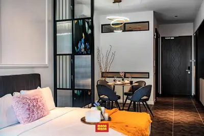 a bedroom with a bed and a table and chairs at Scarletz Mana-Mana Suites KLCC in Kuala Lumpur