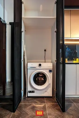 a washer and dryer in a kitchen with a door open at Scarletz Mana-Mana Suites KLCC in Kuala Lumpur