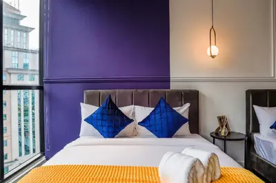 a bedroom with purple walls and a bed with blue pillows at Scarletz Mana-Mana Suites KLCC in Kuala Lumpur