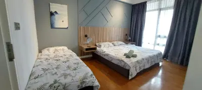a bedroom with two beds and a teddy bear on the bed at Anggun Presidential Suites in Kuala Lumpur