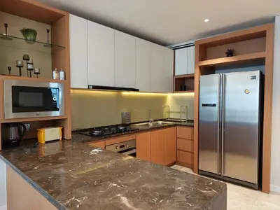a large kitchen with a stainless steel refrigerator at Anggun Presidential Suites in Kuala Lumpur