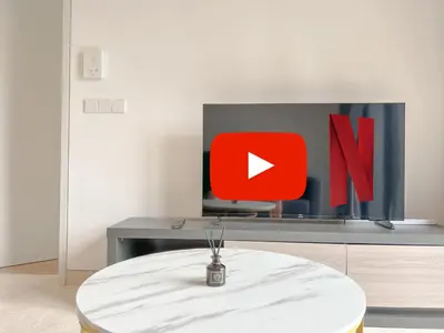 a table in a room with a tv with a red sign at Lucentia Residences BBCC at Lalaport Kuala Lumpur by Veedu Hauz in Kuala Lumpur